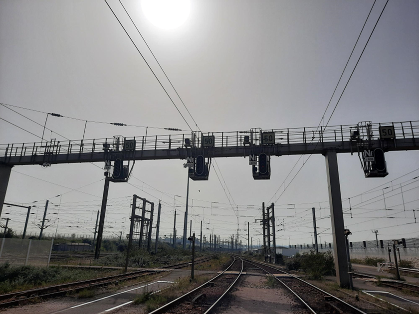 Photograph showing railway signals, track and overhead line equipment at Calais Frethun freight yard.