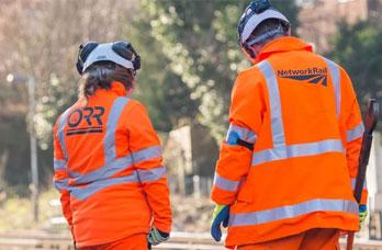 An ORR inspector and Network Rail employee in high visibility clothing