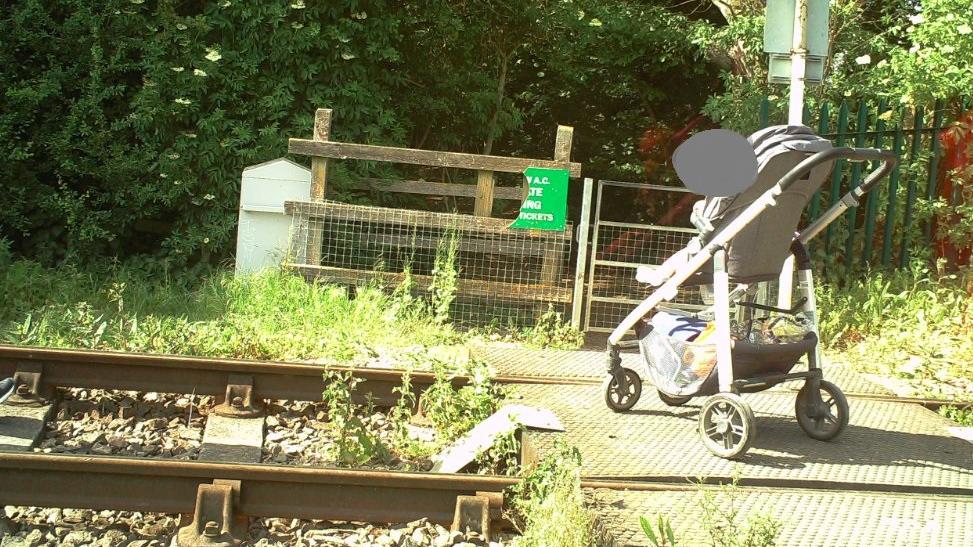 An image of a pram on the railway tracks