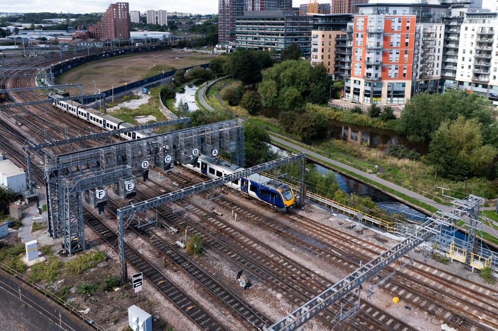 Aerial view of passenger train, tracks, and overhead line equipment