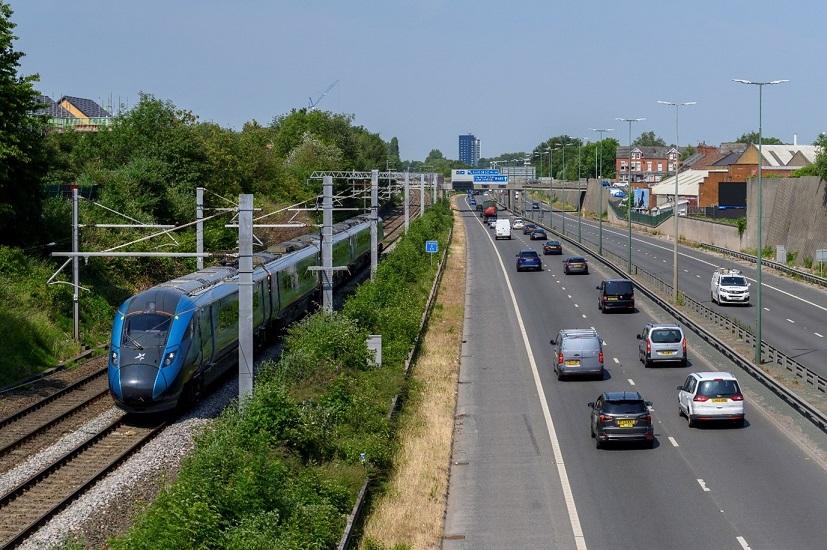 A train on the tracks with cars on the side