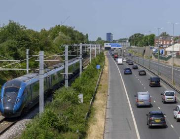 Railway track with train beside a road